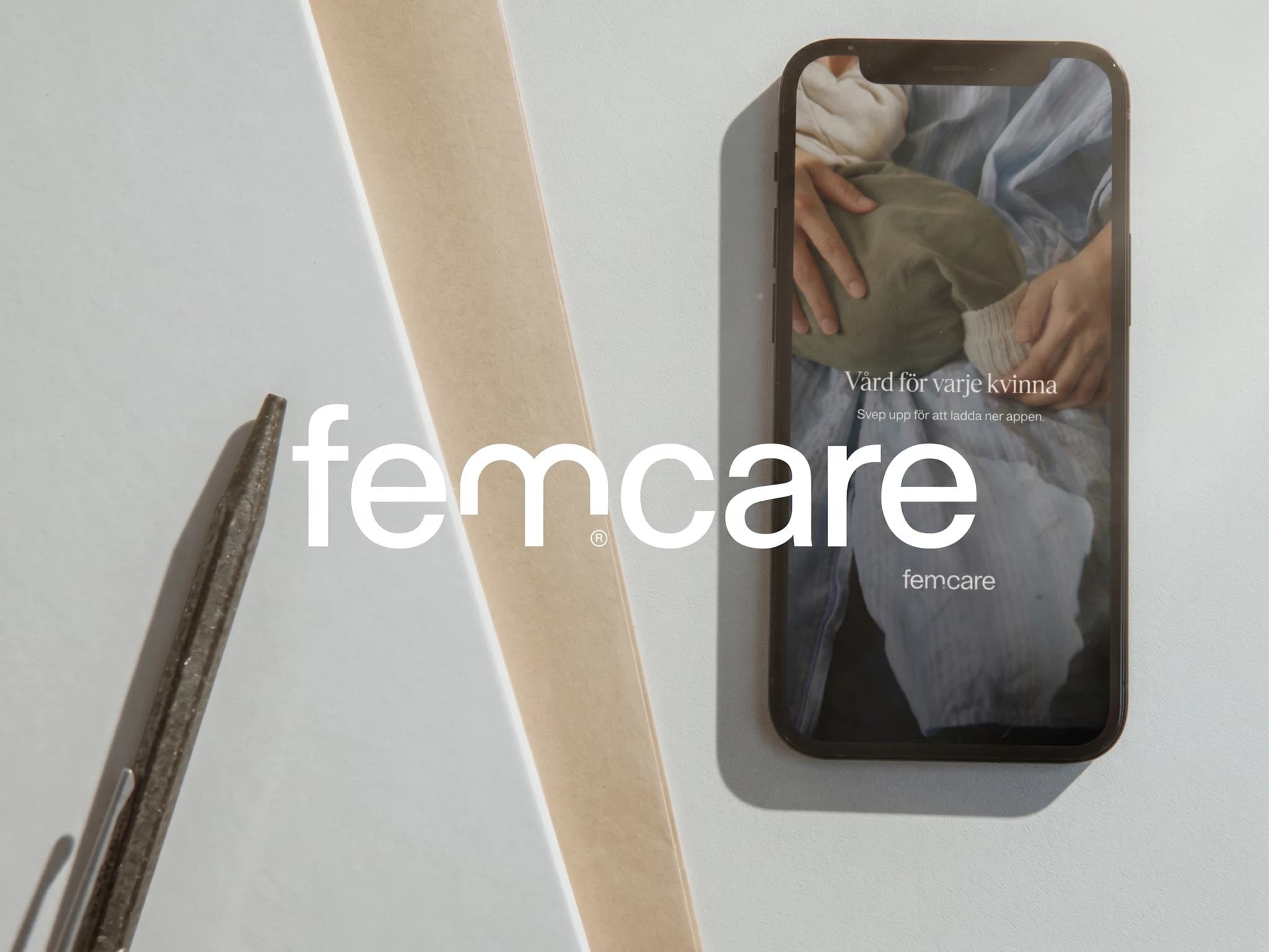 En smartphone visar appen Femcare med texten 'Vård för varje kvinna' och 'Svep upp för att ladda ner appen'. Texten 'femcare' visas även i förgrunden.