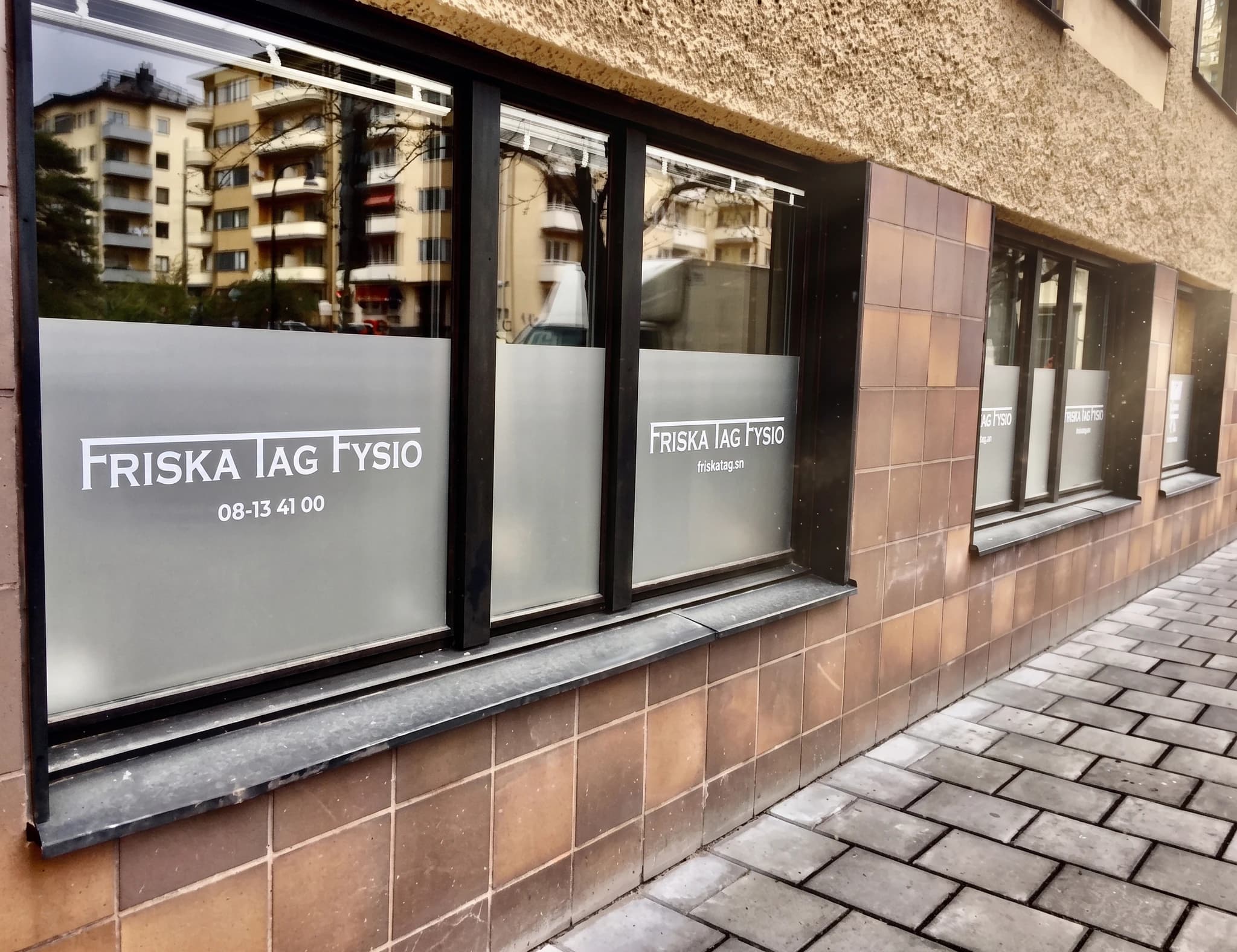 Fönster med texten 'Friska Jag Fysio' och telefonnummer.