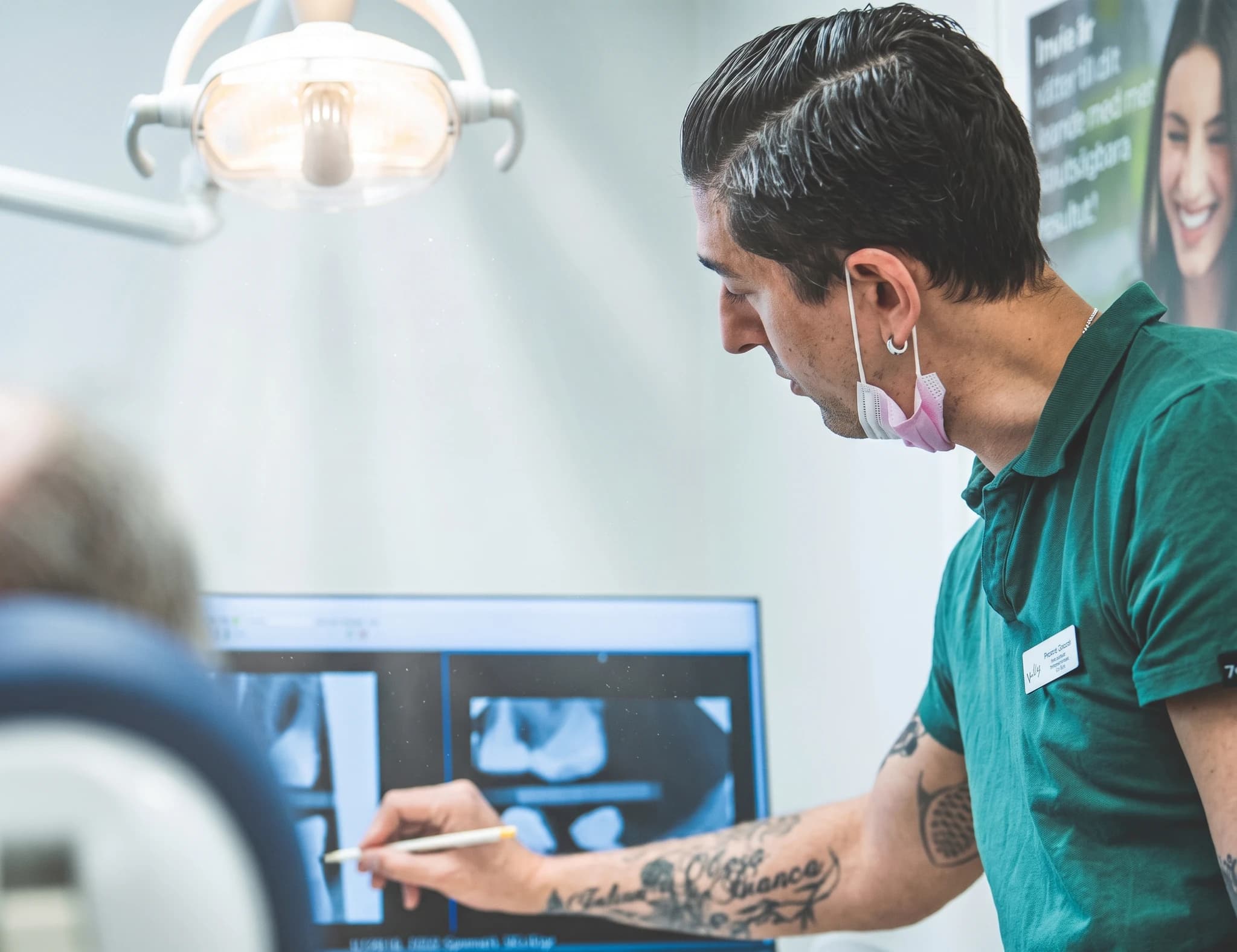 Tandläkare undersöker dentalröntgenbilder på en datorskärm.