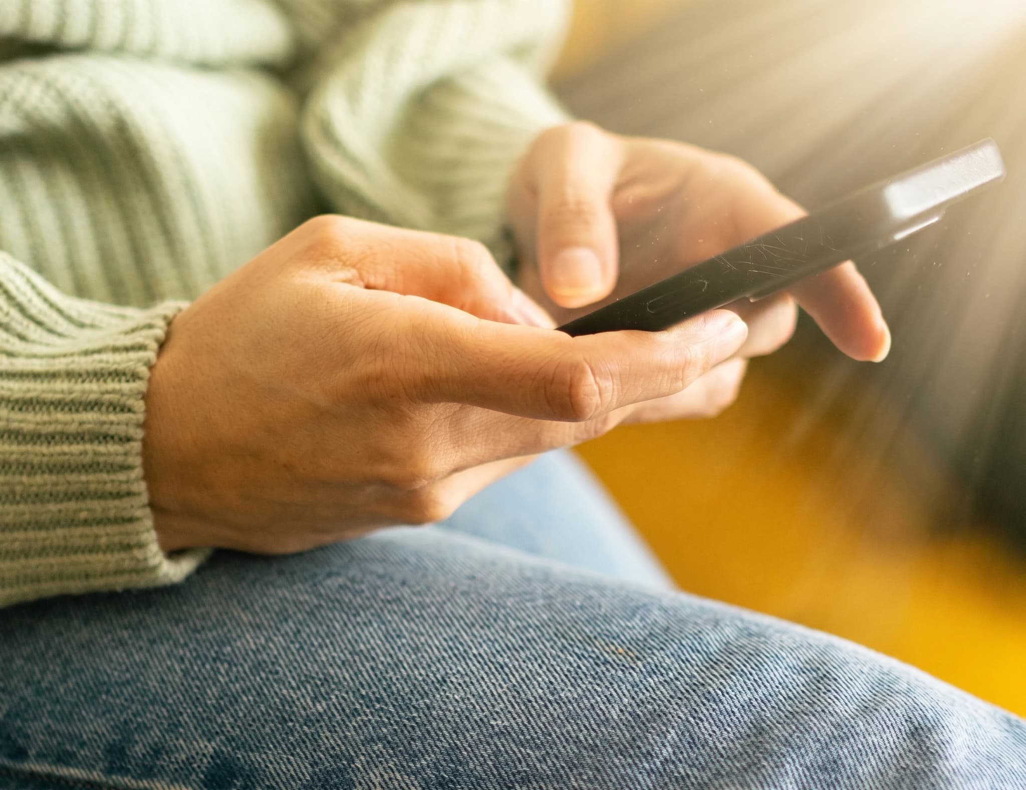 Närbild på händer som använder en smartphone.