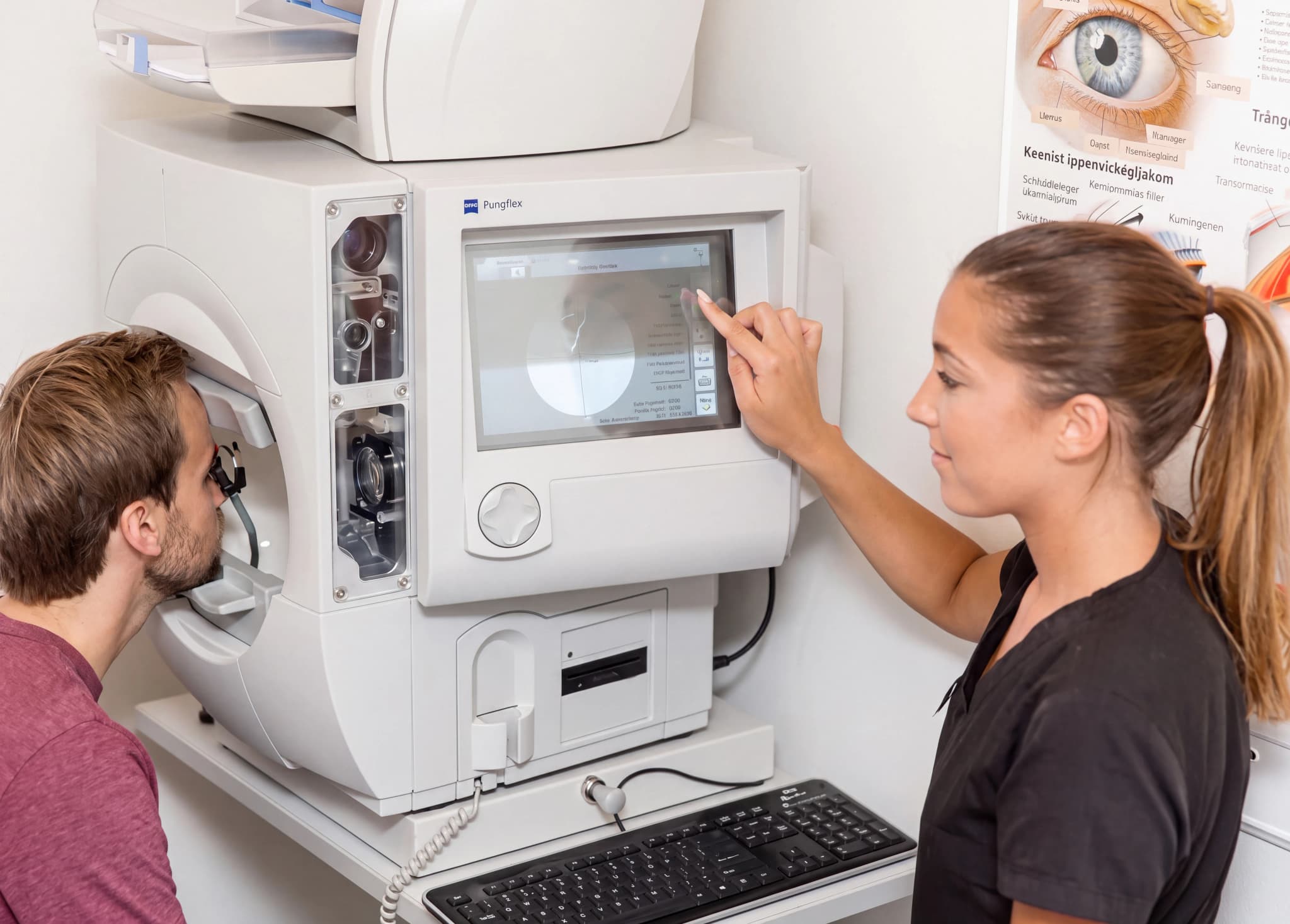 Optiker undersöker patientens ögon med en modern ögonundersökningsmaskin medan hon hanterar displayen.