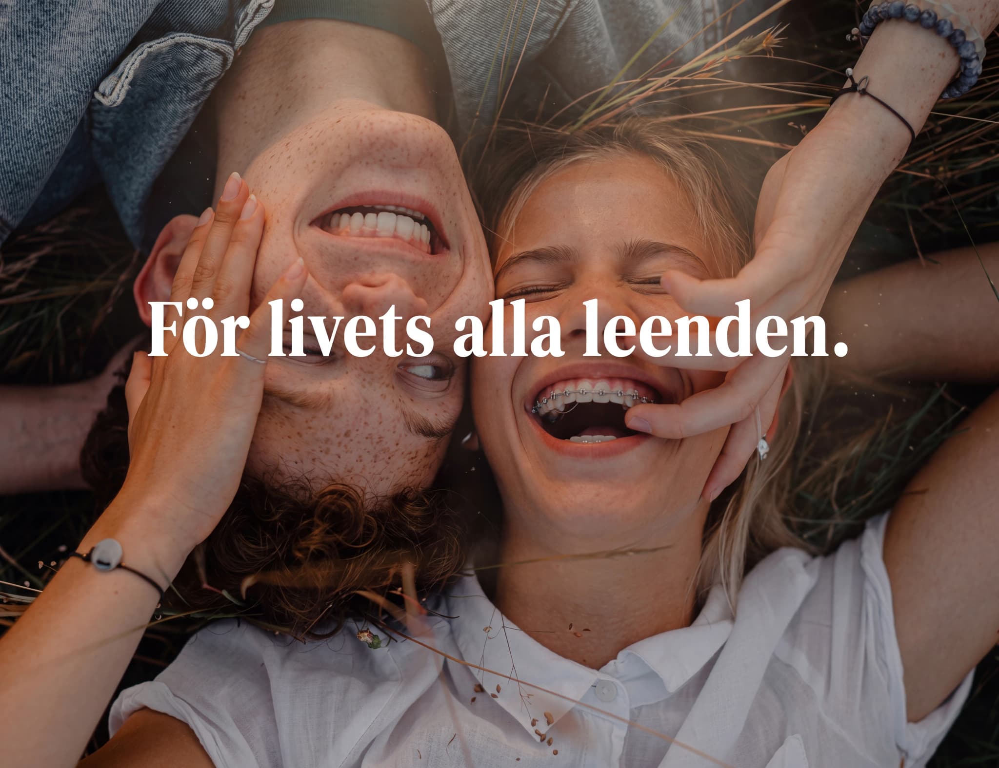 Ungt par som skrattar tillsammans utomhus med texten "För livets alla leenden."