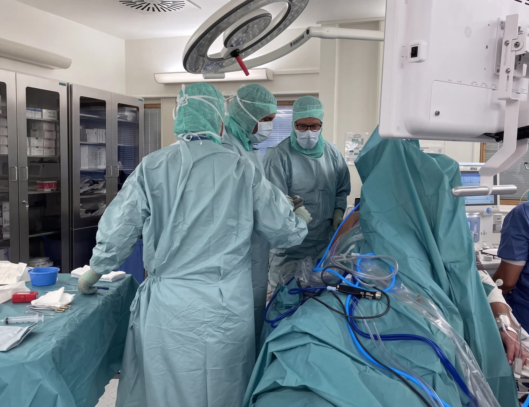Kirurger utför operation i ett modernt operationsrum med medicinsk utrustning.