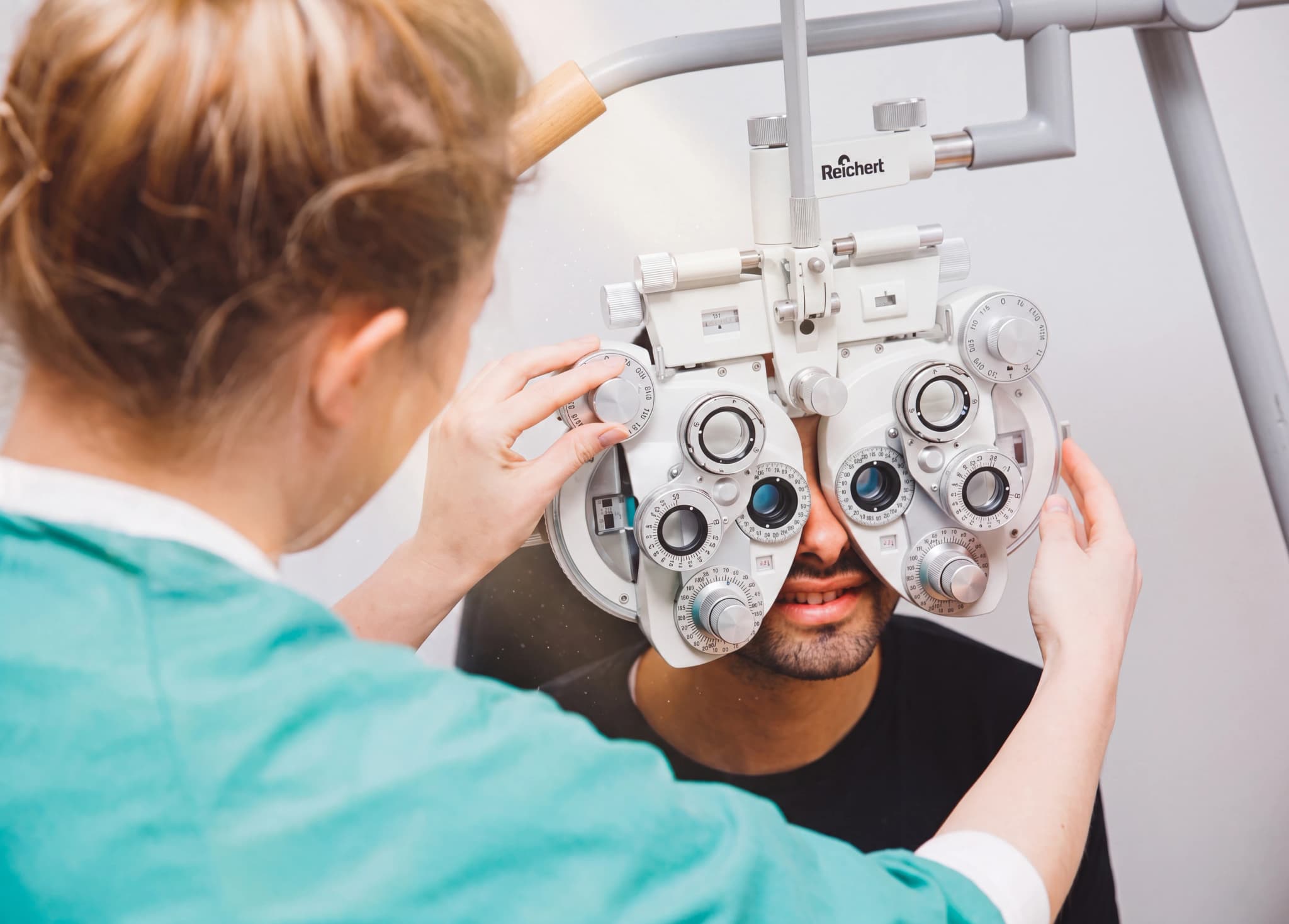 Optiker använder en phoropter för att undersöka en patients ögon.