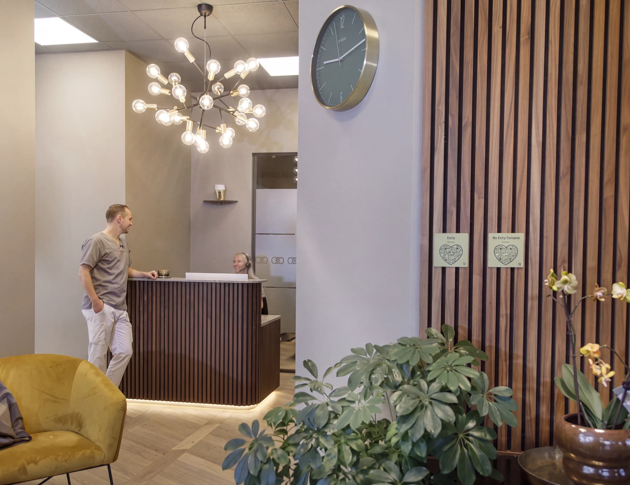 En kvinna bakom en reception i en klinik och en man står vid sidan av.
