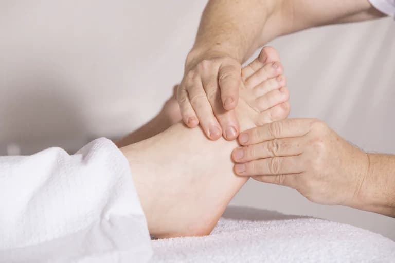 En person får en fotmassage i en klinikmiljö.