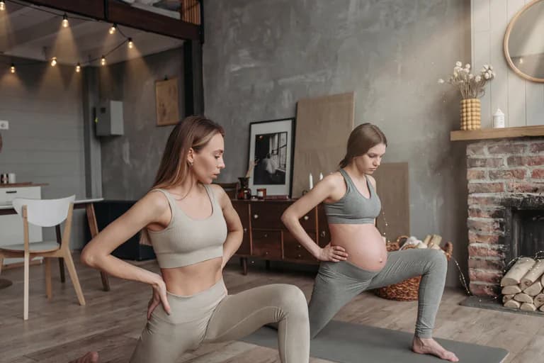 En gravid kvinna och en annan kvinna gör yogaövningar i vardagsrummet.