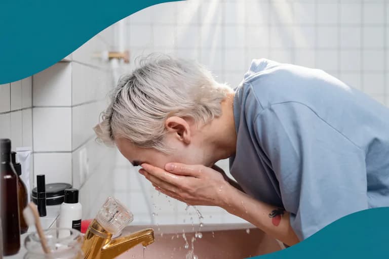 Person med grått hår tvättar ansiktet i ett handfat i ett badrum.