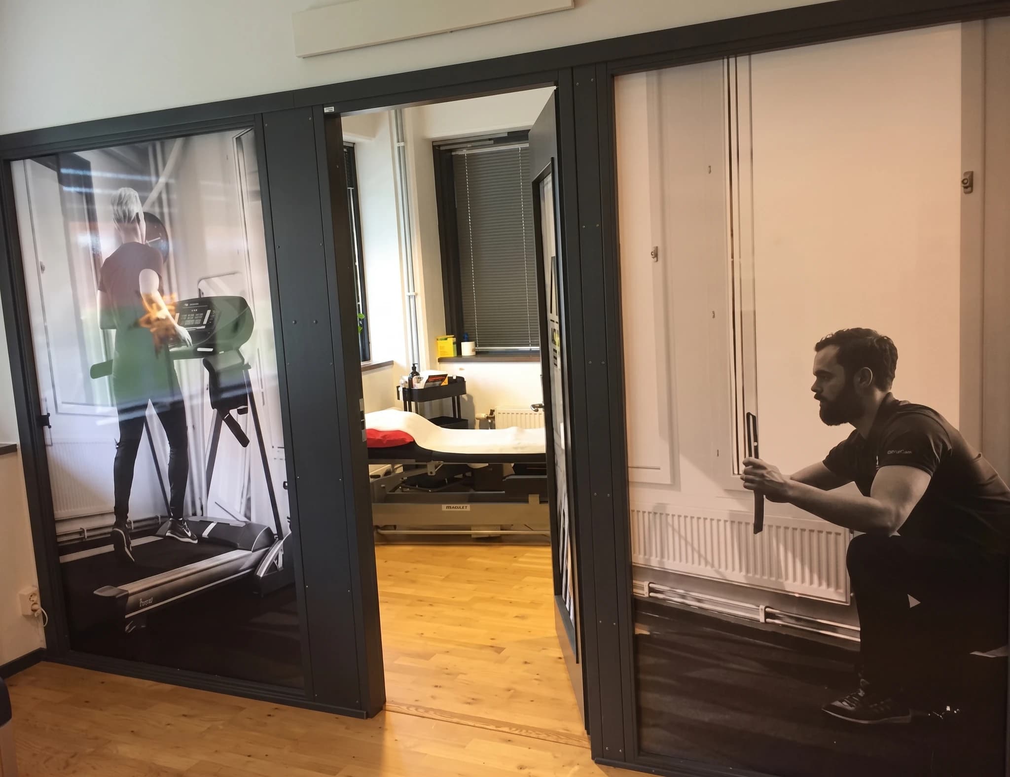 Interiör av ett gym med stora affischer på väggarna som visar personer som tränar.