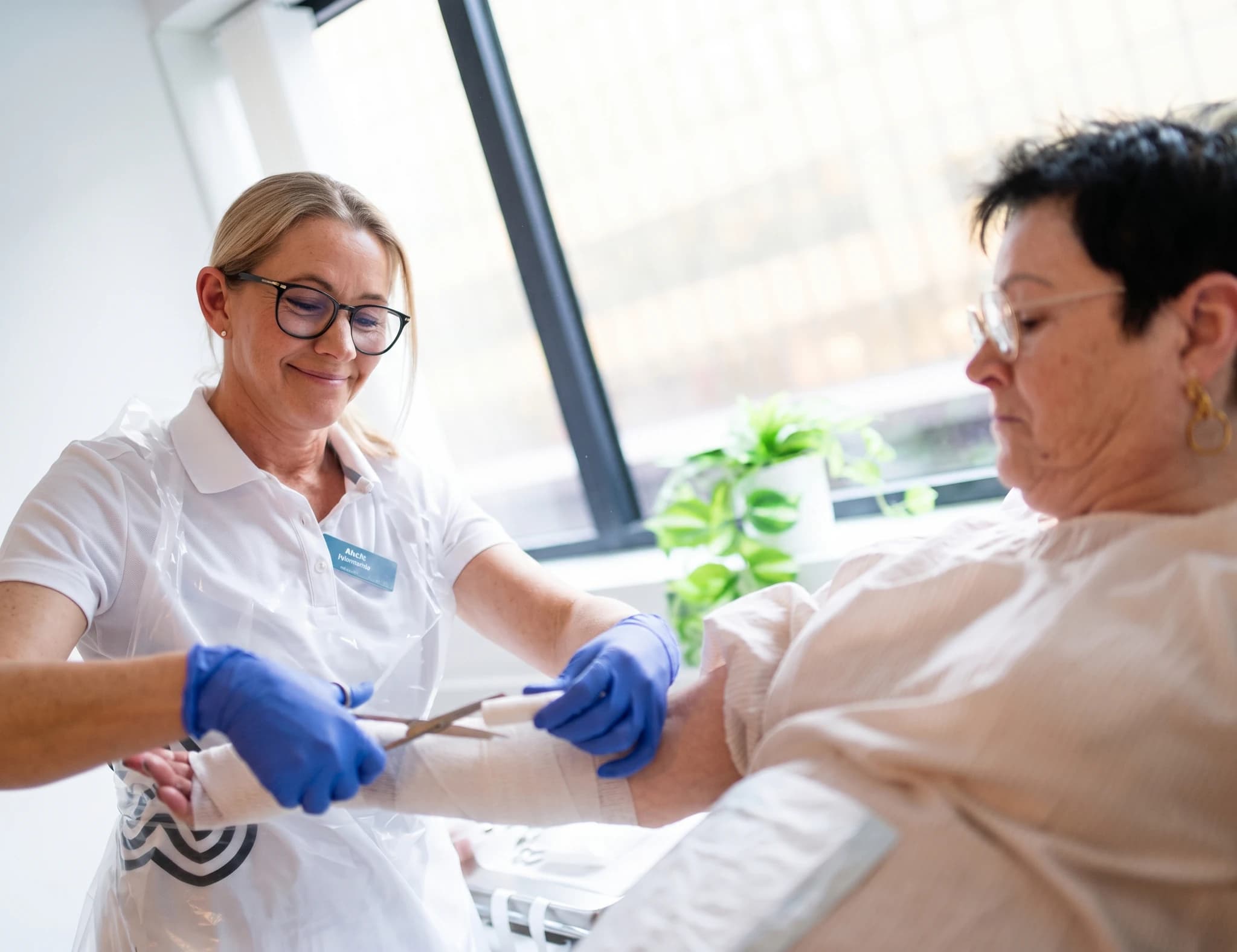 Sjuksköterska klipper bort gips på en patients arm med en sax.