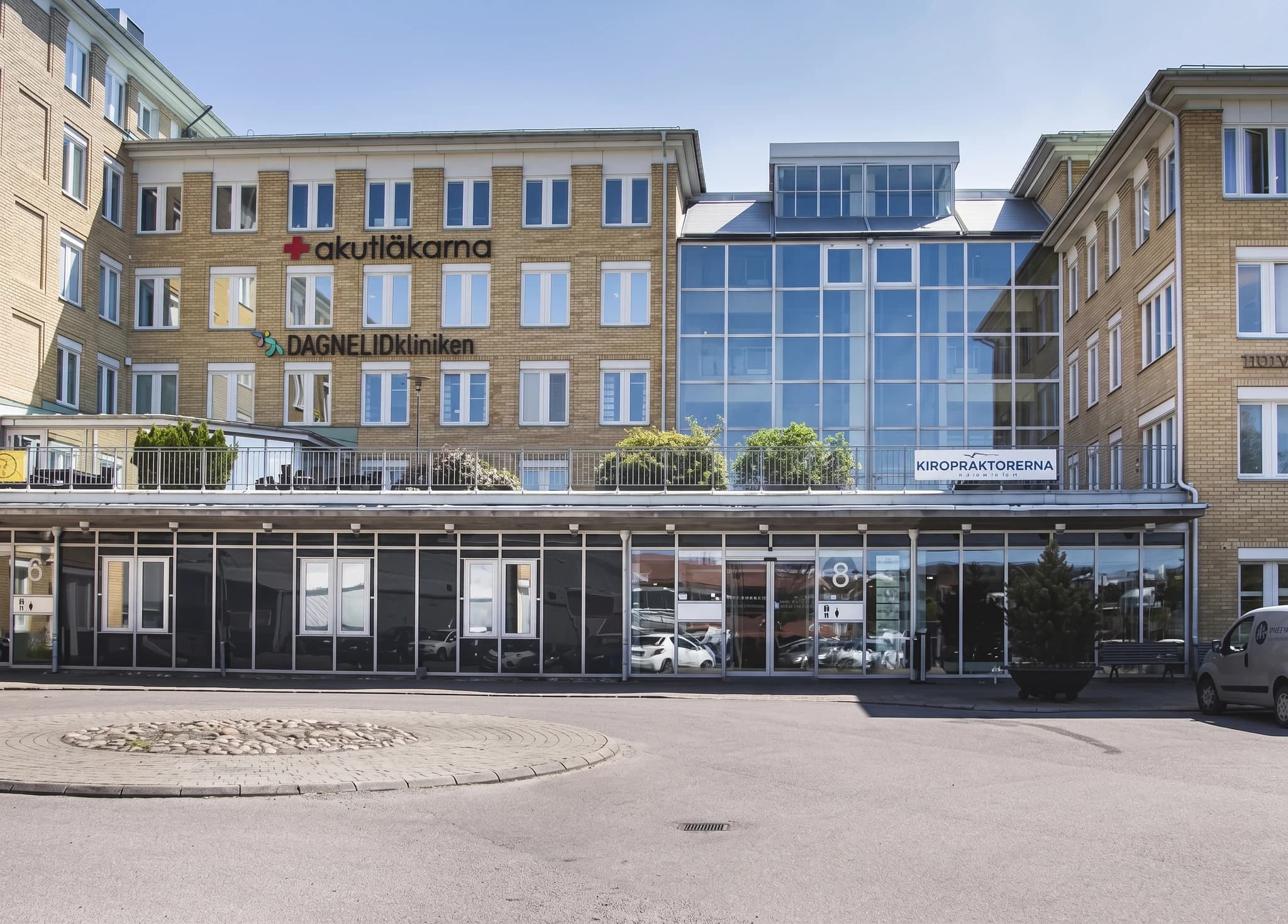 Exteriörbild av en modern byggnad med texten 'Akutläkarna' och 'Dagnelidkliniken'.