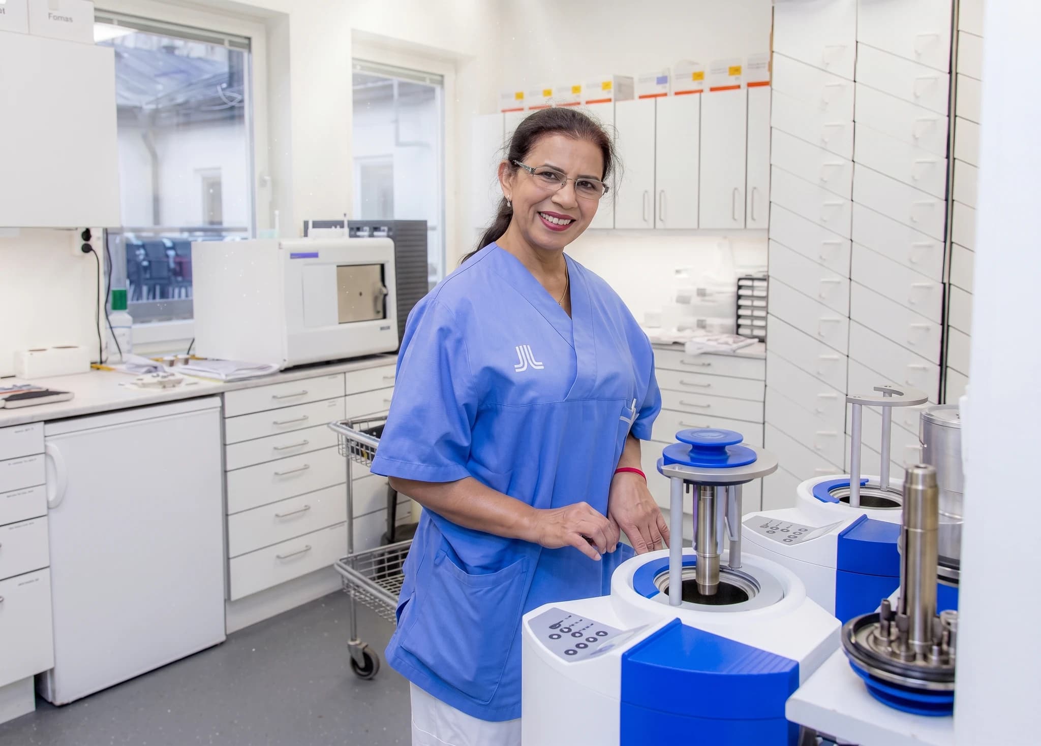Sjuksköterska som arbetar med laboratorieutrustning i en klinik.