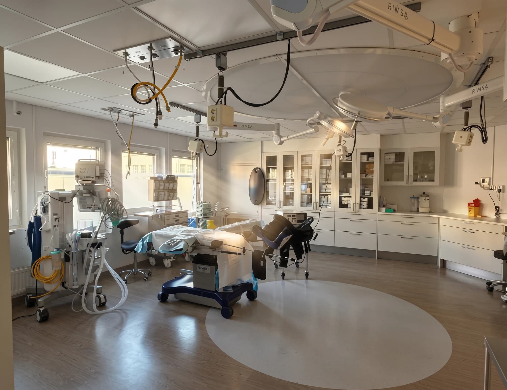 Operationssal med kirurgisk utrustning, operationsbord och skåp fyllda med medicinsk utrustning.