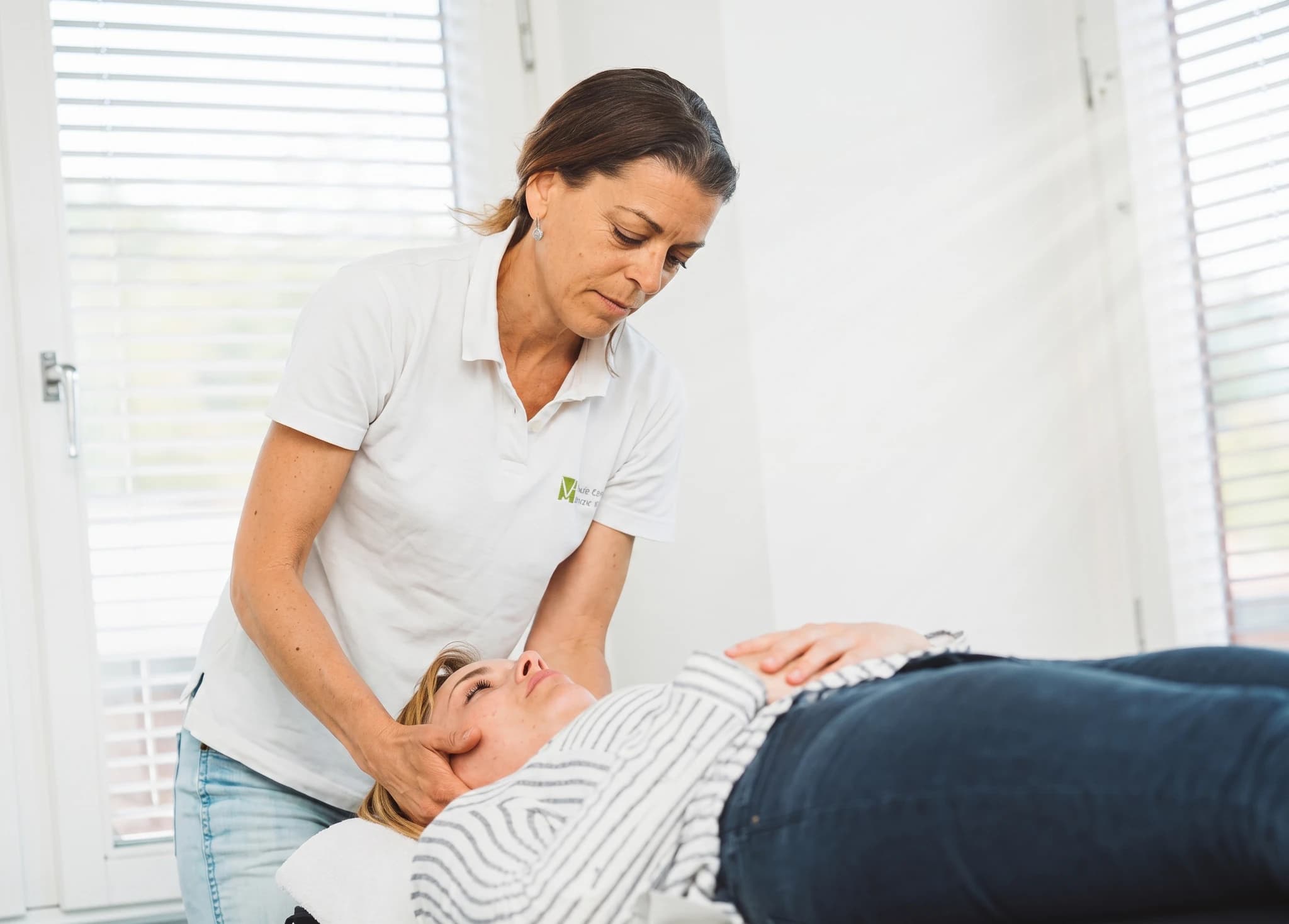 Terapeut masserar en patients huvud under en behandling.