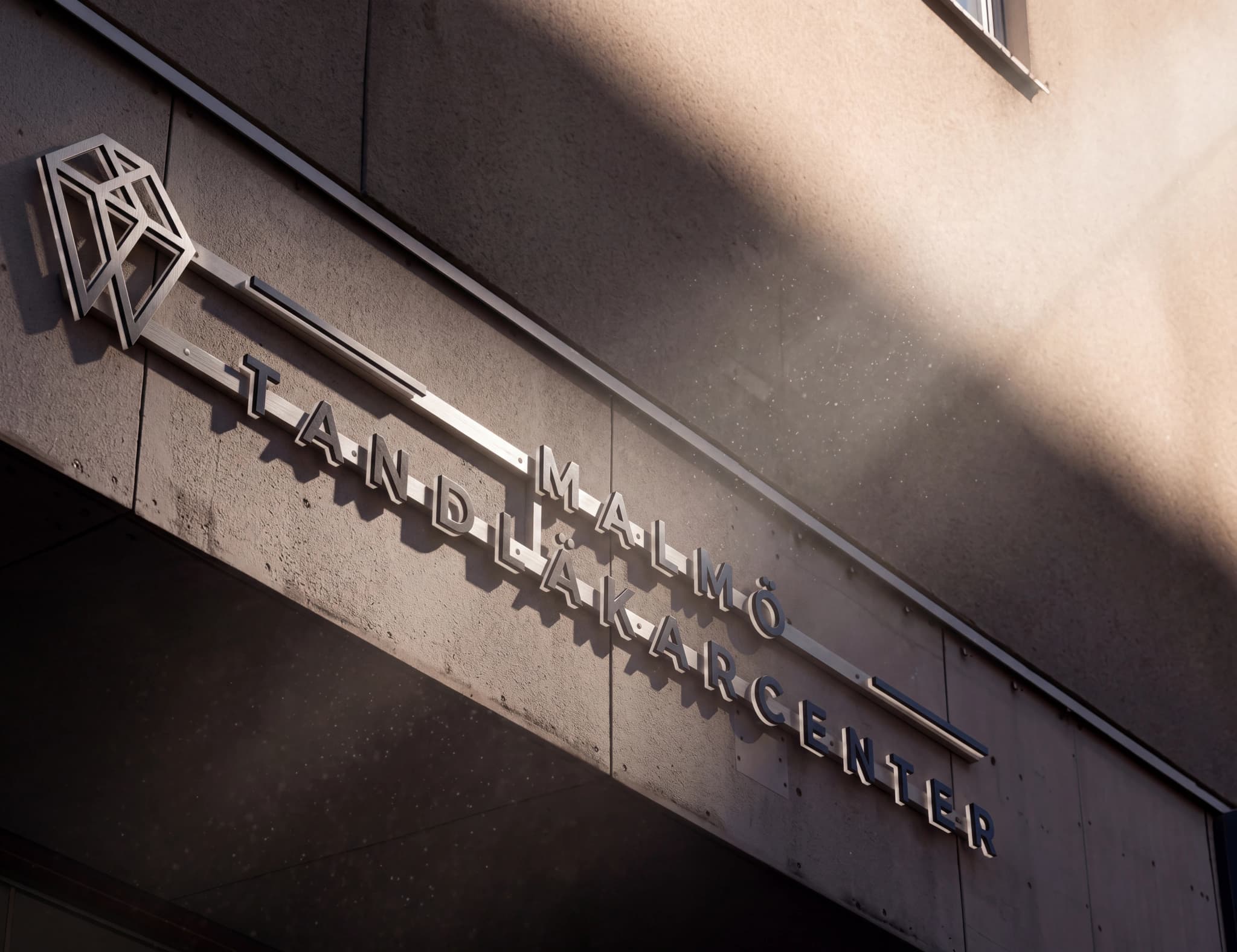 Utskriftsbild av ett skylt med texten "MALMÖ TANDLÄKARCENTER" och en logotyp.