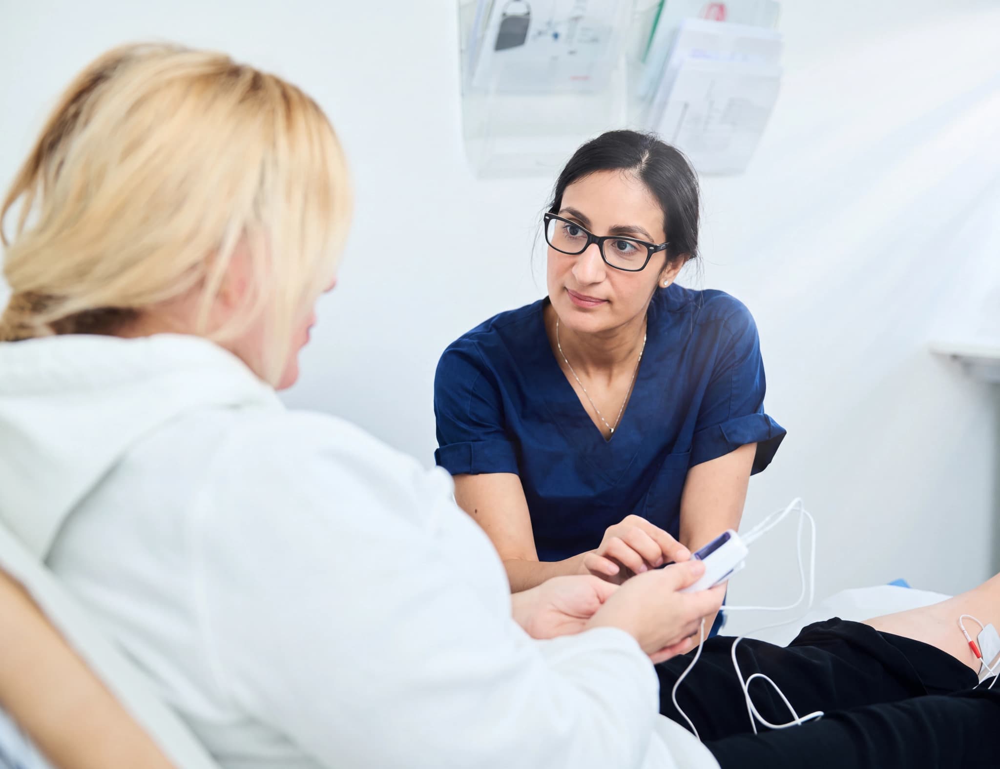 Läkare mäter syresättning med pulsoximeter på en patient som ligger i en säng.