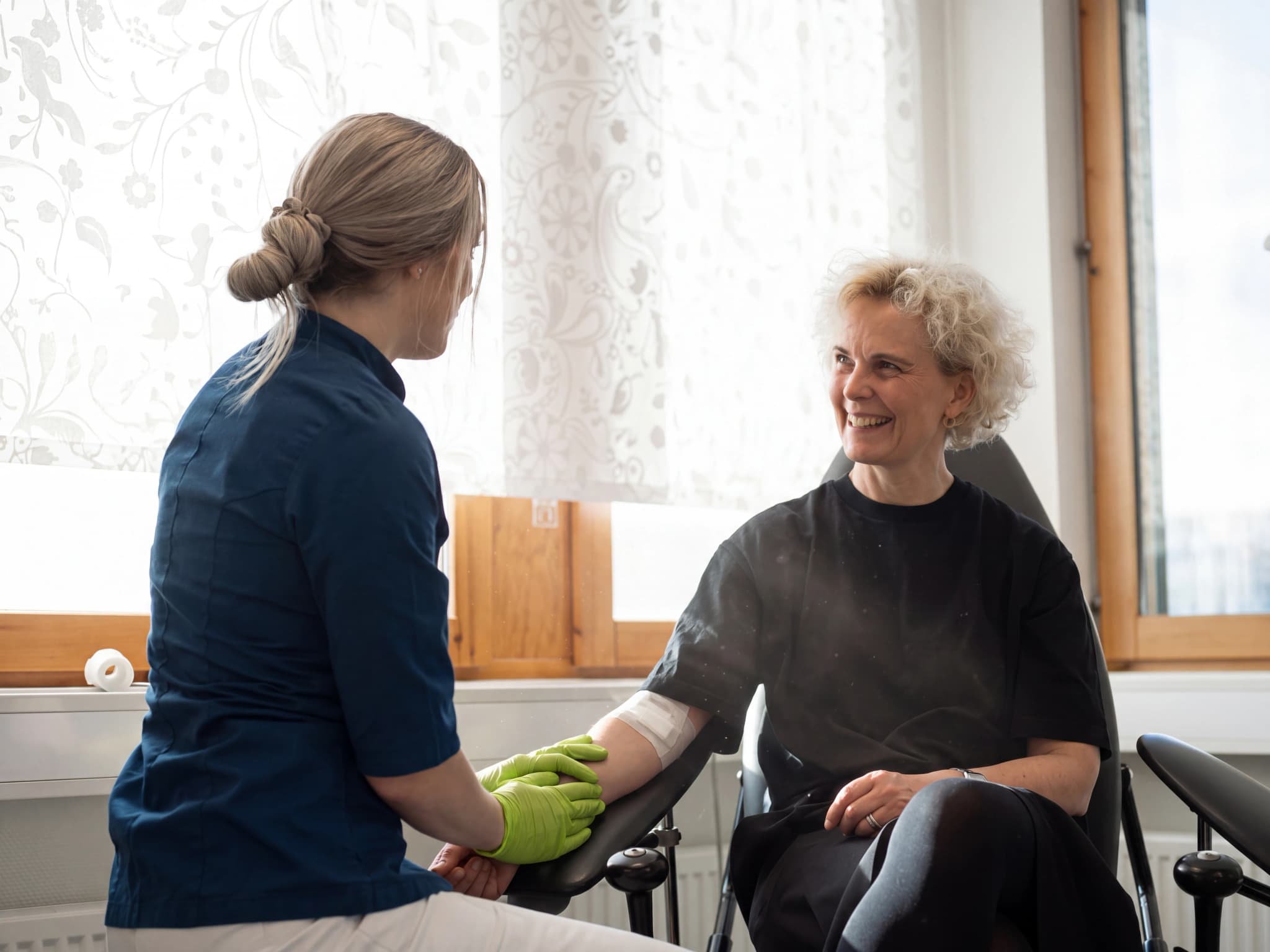 Sjuksköterska ger en injektion till en patient i en bekväm stol på en klinik.