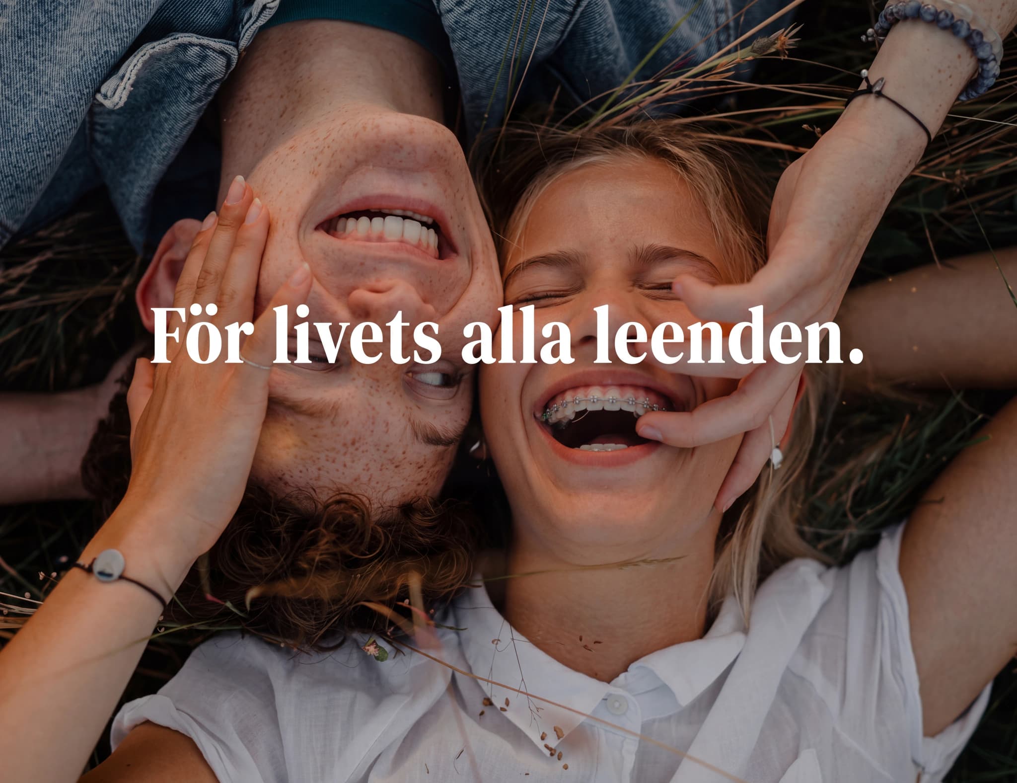 Unga människor som skrattar tillsammans utomhus på gräs, med texten "För livets alla leenden."