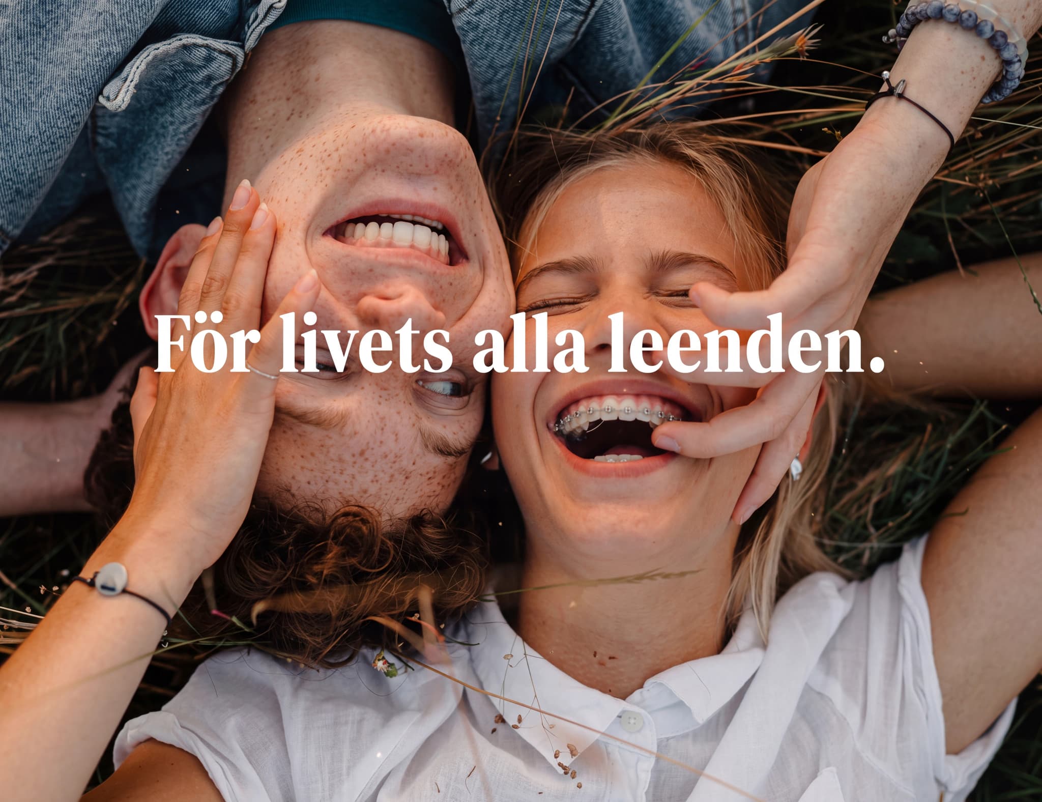 Ungt par som skrattar tillsammans utomhus.