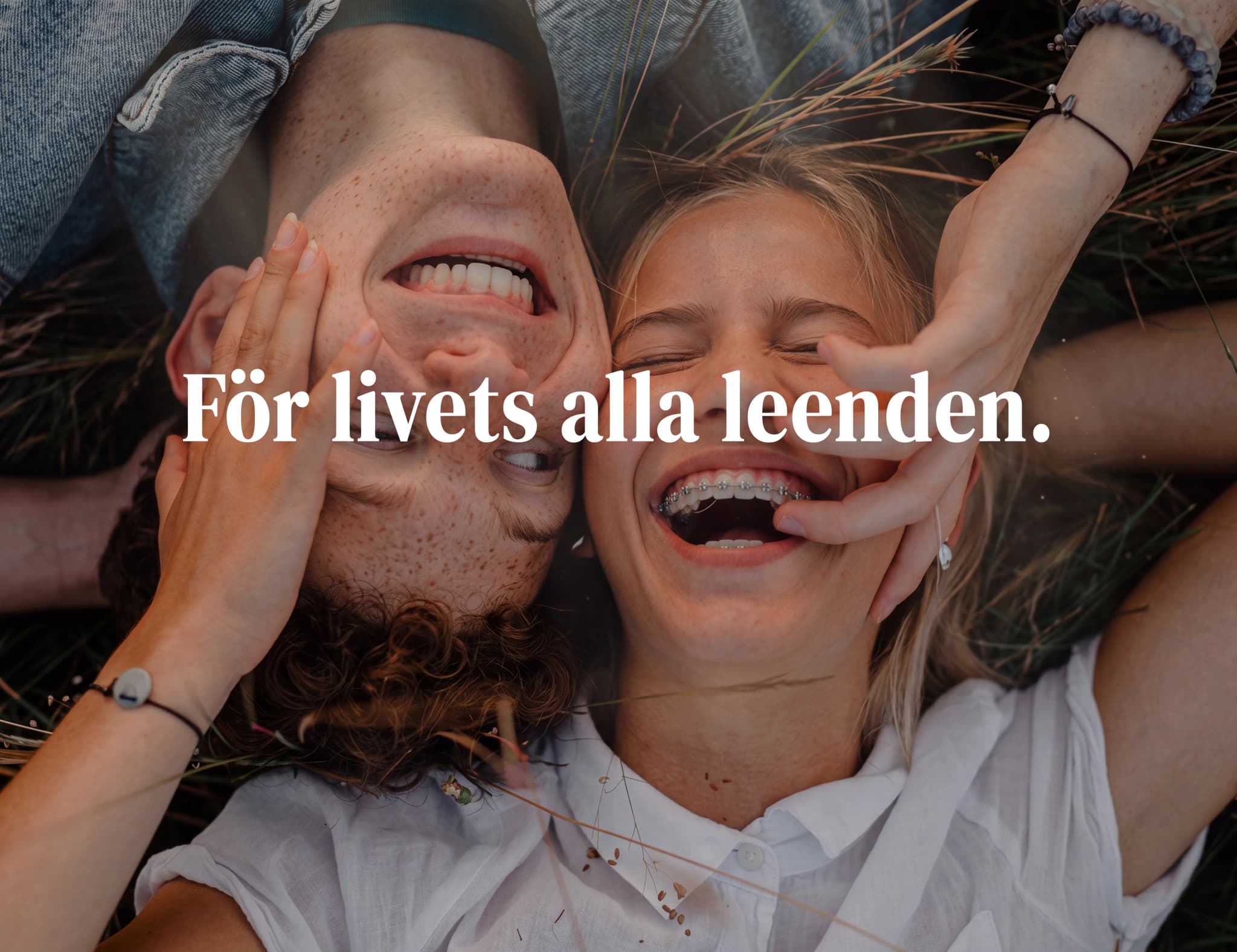 Ett ungt par som skrattar tillsammans utomhus, med texten 'För livets alla leenden.'