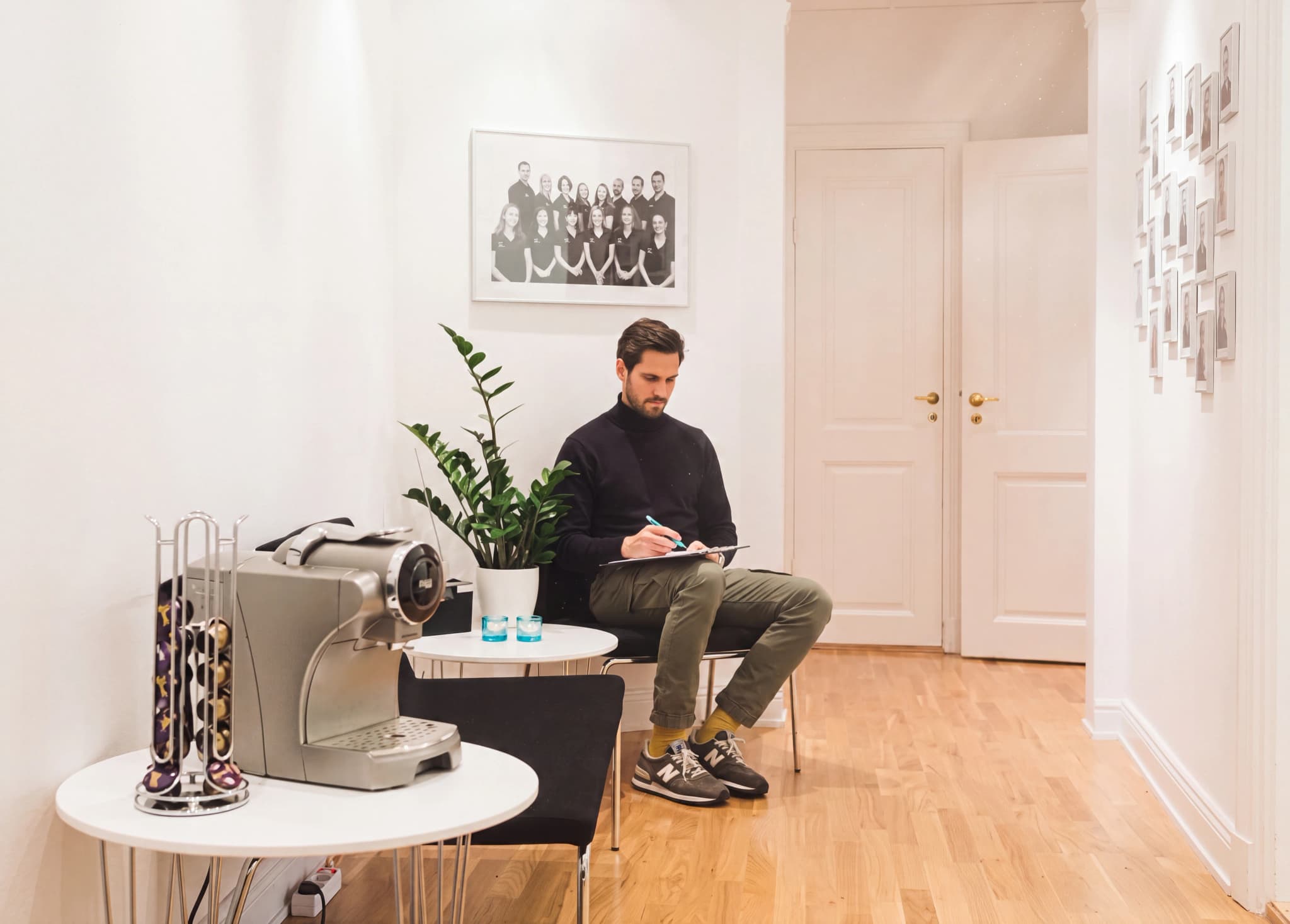 Man sitter i ett väntrum och fyller i formulär på ett block.