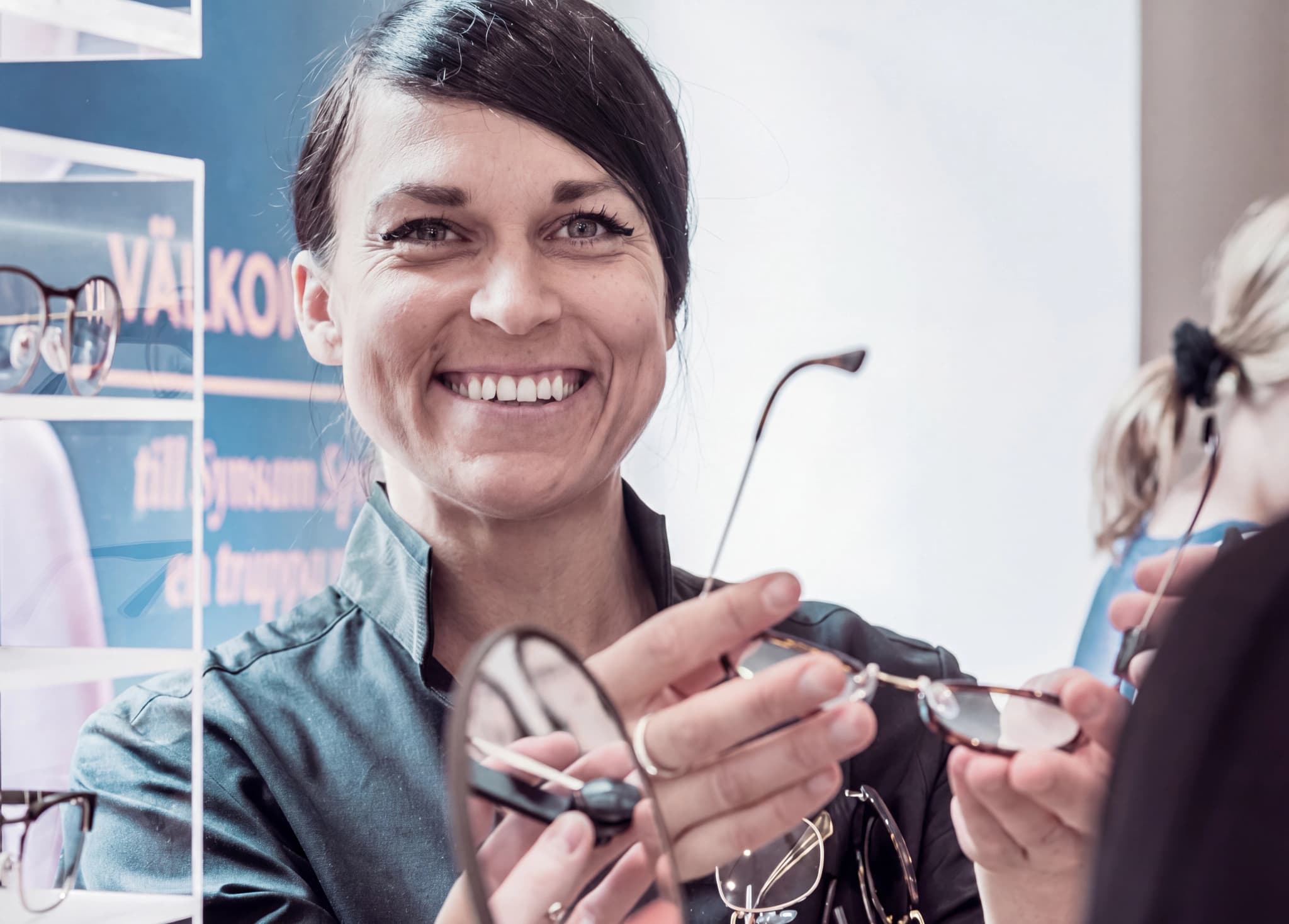 Optiker visar glasögon till kund i butik