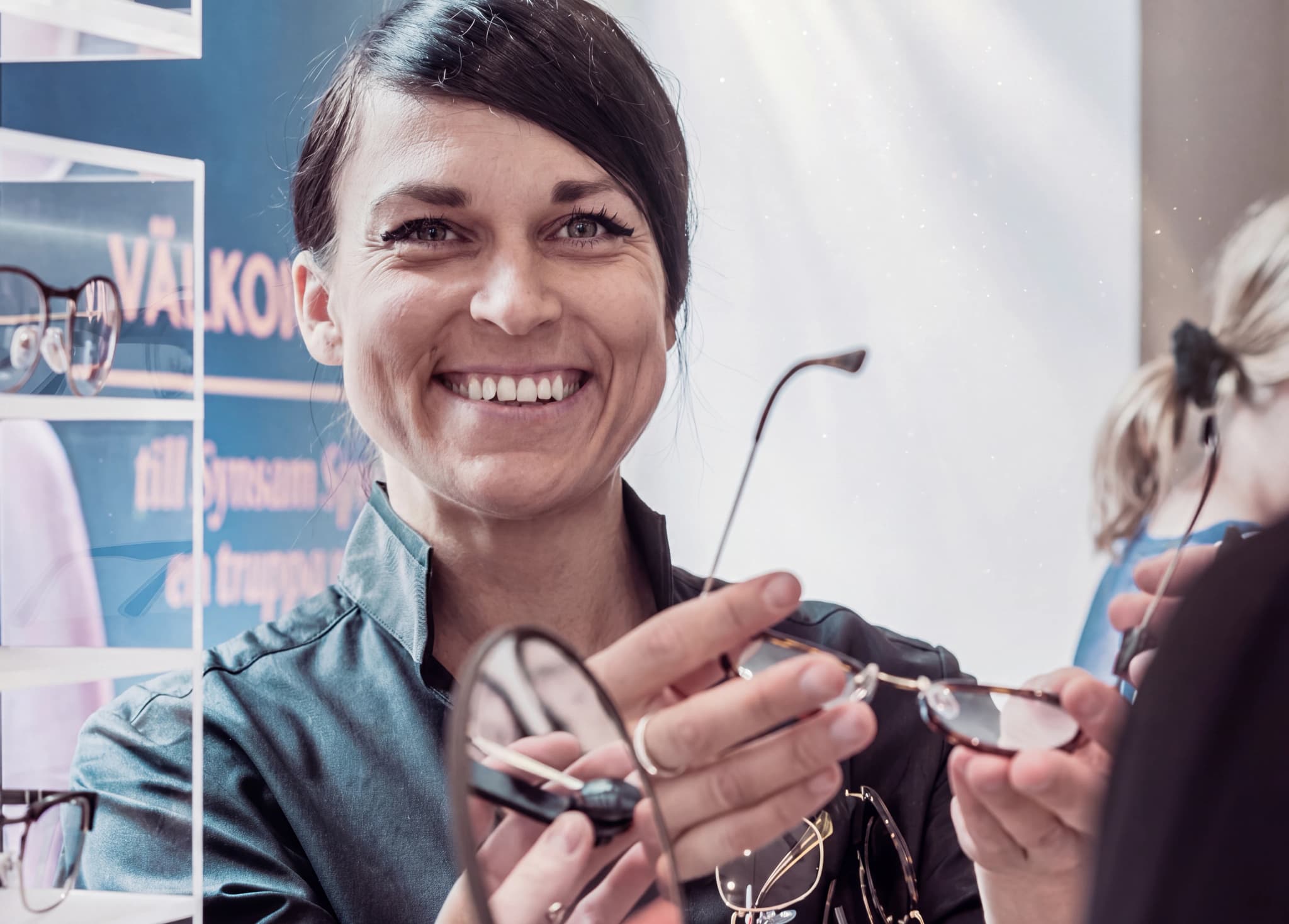 Optiker visar glasögon för en kund i en butik