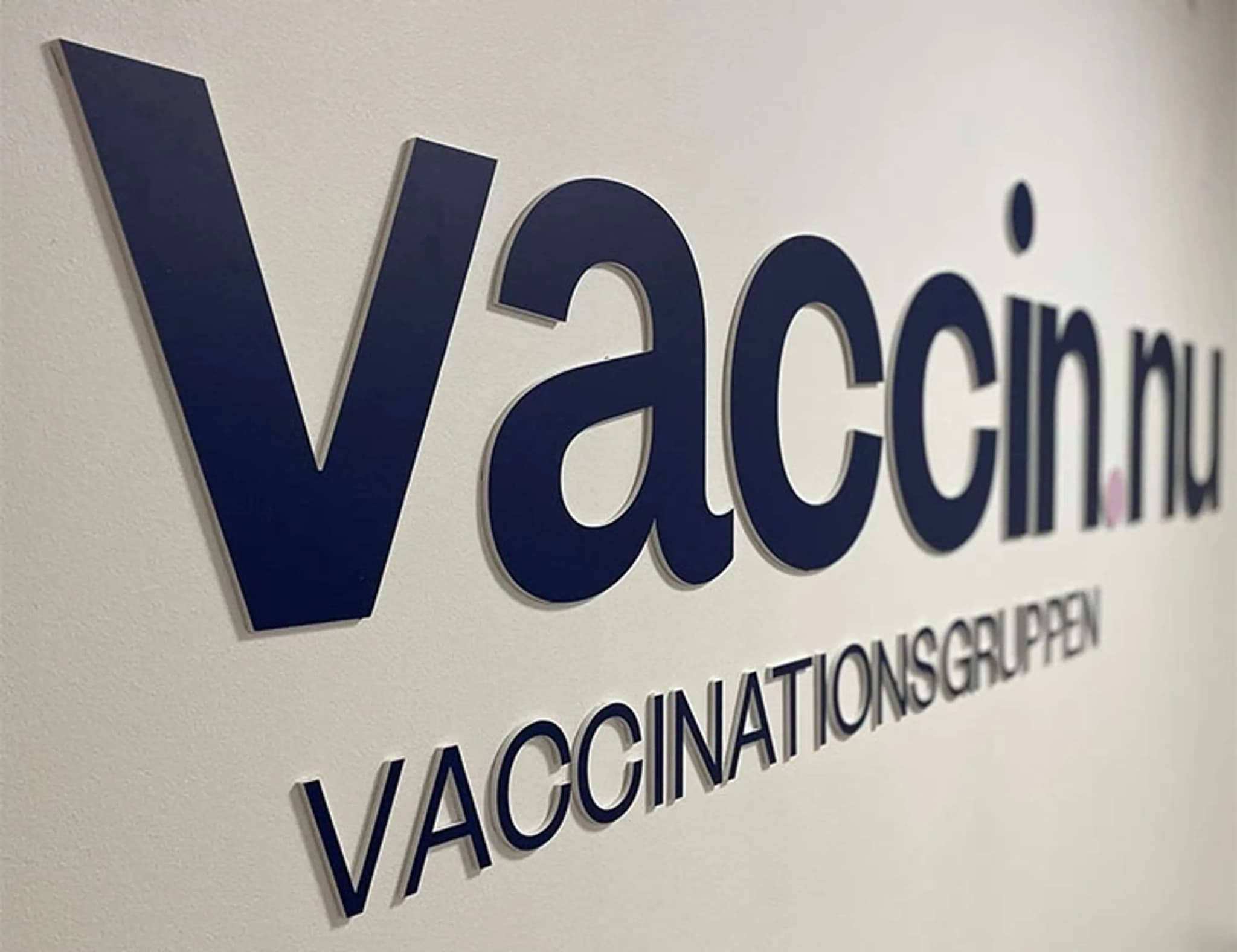 Vaccin.nu och Vaccinationsgruppen logotyp i 3D-bokstäver på en vit vägg.