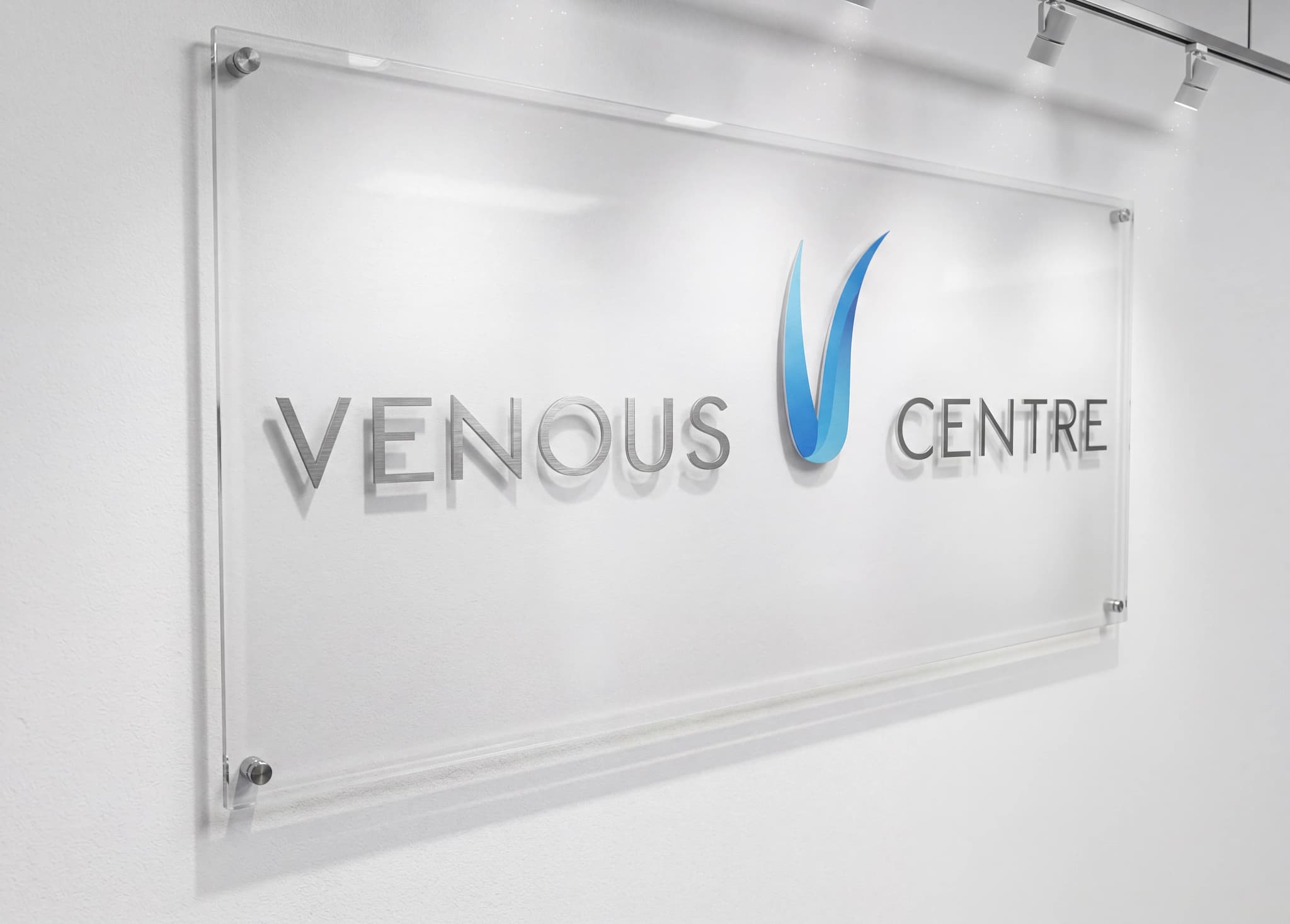 Logotyp och text för Venous Centre monterad på en vit vägg.