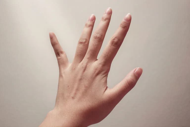 En hand som visar fem fingrar, tagen i närbild mot en ljus bakgrund.