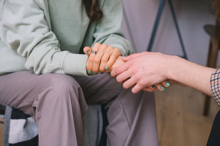 En terapeut håller patientens hand för att ge stöd i en terapisession.