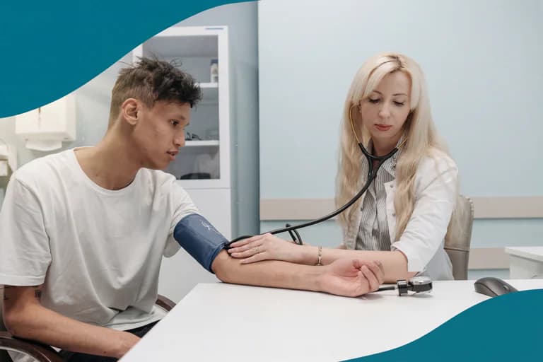Läkare med stetoskop mäter blodtrycket på en manlig patient i ett undersökningsrum.