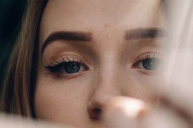 Närbild på en kvinnas ögon med dramatisk eyeliner och ögonskugga, som tittar rakt fram.